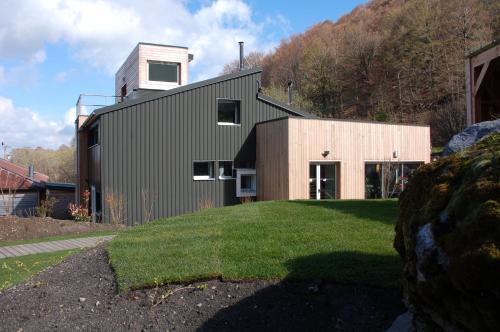 a house on a hill with a grass yard at Aux 500 Diables Eco Lodge - Hotel in Chambon-sur-Lac