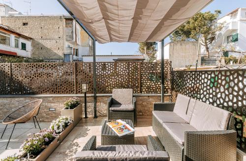 a patio with a couch and chairs and a table at Villa Amato Rooms & Apartment in Ischia
