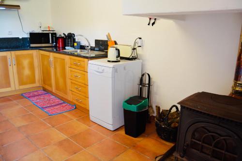a kitchen with a white refrigerator and a stove at Fatima Villas in Ourém