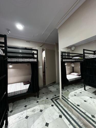 a room with three bunk beds and a mirror at SREA Homestead Dormitory in New Delhi