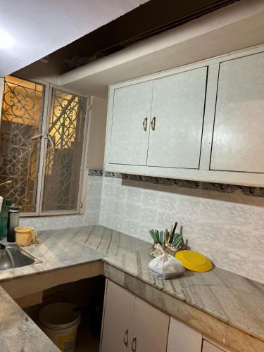 a kitchen with a counter with a yellow plate on it at SREA Homestead Dormitory in New Delhi