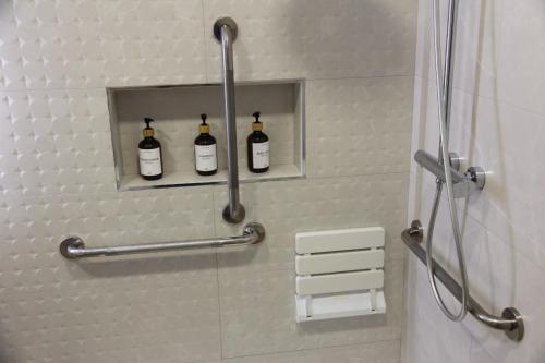 a bathroom with three bottles of wine on a shelf at Ruzafa Alegria in Valencia