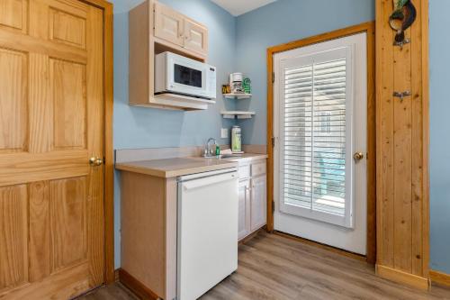 a kitchen with a sink and a microwave at Courtyard Villas On Silver Lake in Ocracoke