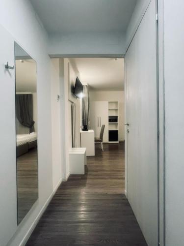a hallway leading to a room with white walls and wood floors at Hotel Holiday- Alla Finestrella in Bologna