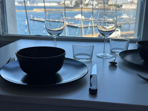 - une table avec un bol et des verres à vin dans l'établissement Appartement Design VII Port de Tréboul-Douarnenez, à Douarnenez