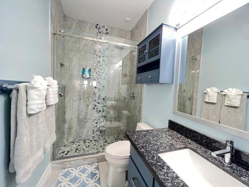 a bathroom with a shower with a toilet and a sink at Fam Reunion, Beachview, EV charger Heated Pool, Jacuzzi, Billiard in South Padre Island