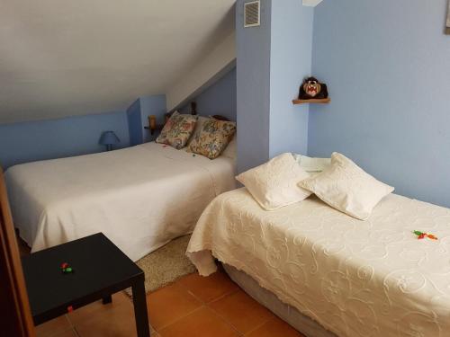 a bedroom with two beds and a small table at El Bosque Rural House in El Bosque