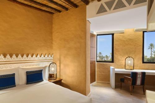 a bedroom with a bed and a desk and windows at Bab Samhan, a Luxury Collection Hotel, Diriyah in Riyadh