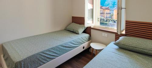 a small bedroom with two beds and a window at Super Attico in Verbania