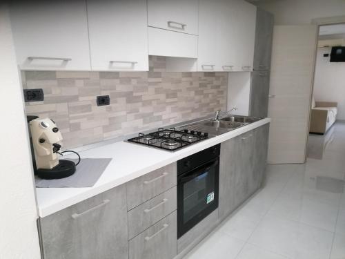 a kitchen with a stove and a sink at Casa VERDE MAREMONTI in Ischia