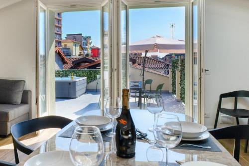 a table with glasses and a bottle of wine on it at Super Attico in Verbania