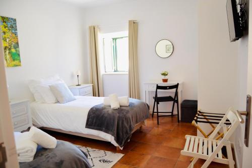a bedroom with a bed and a table and a chair at Fatima Villas in Ourém