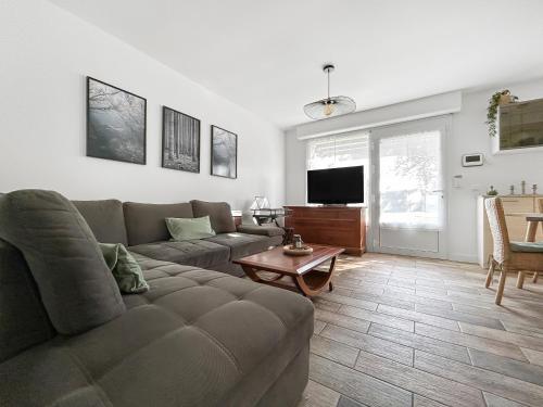 un salon avec un canapé et une télévision dans l'établissement Maison avec grand jardin arboré, à Ferrières