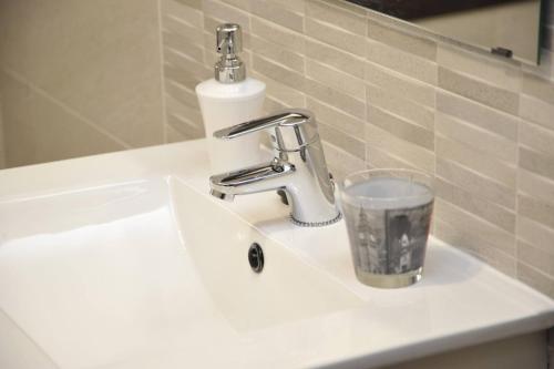 a bathroom sink with a faucet and a glass on it at ADANAR-Las Columnas in Granada