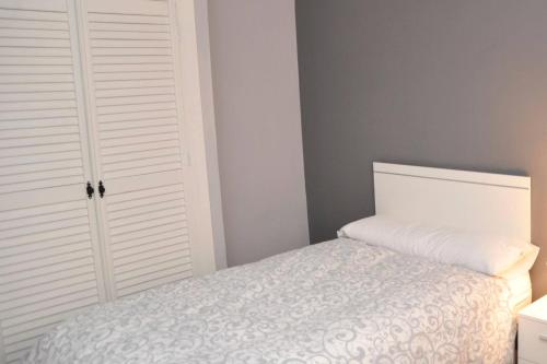 a bedroom with a bed and a white closet at ADANAR-Las Columnas in Granada