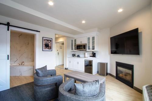 a living room with two chairs and a table and a fireplace at Cedar Street Hotel & Suites in Sandpoint