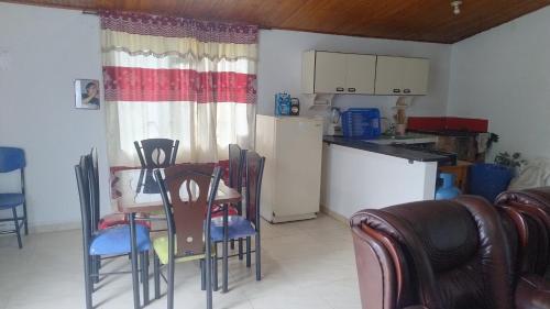 a kitchen with a table and chairs and a refrigerator at Cabaña El Refugio in Duitama