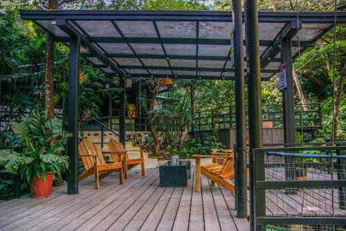 a pergola with chairs and tables on a wooden deck at Buena Vista del Rincón Eco Adventure Park Hotel & Spa in Liberia