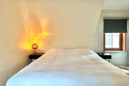 una camera con un letto bianco e una luce sul muro di 04 cosy family villa near Knokke Golf a Knokke-Heist