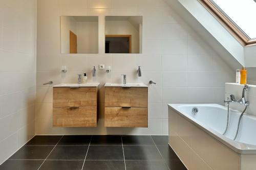 bagno con 2 lavandini e vasca di 04 cosy family villa near Knokke Golf a Knokke-Heist