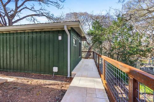 a green building with a fence next to it at Cowboy Casita in Wimberley