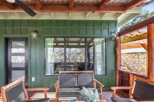 a green house with two chairs on a porch at Dew Drop Inn in Wimberley