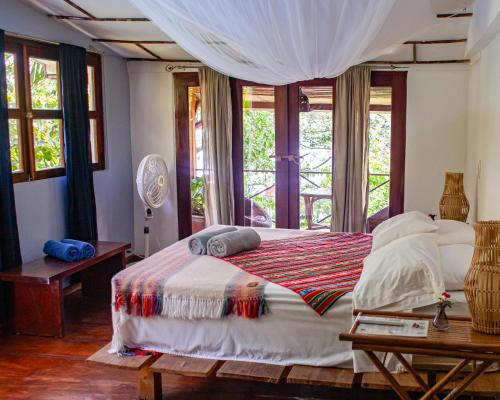 a bedroom with a large bed with windows at Casa Marimba in La Laguna