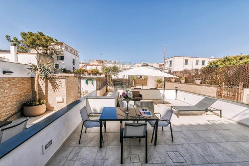 a patio with a table and chairs on a balcony at Villa Amato Rooms & Apartment in Ischia