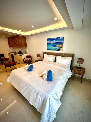 a bedroom with a large white bed with blue towels on it at Santa Barbara Sea front resort and spa in Polis Chrysochous