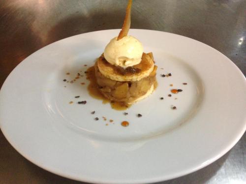 a dessert on a white plate with a scoop of ice cream at Aux 500 Diables Eco Lodge - Hotel in Chambon-sur-Lac