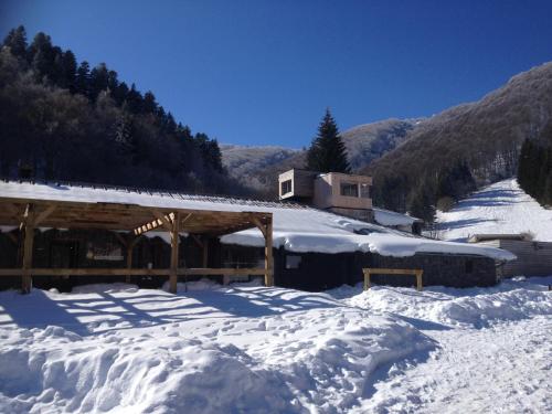 a snow covered building with a snow covered roof at Aux 500 Diables Eco Lodge - Hotel in Chambon-sur-Lac