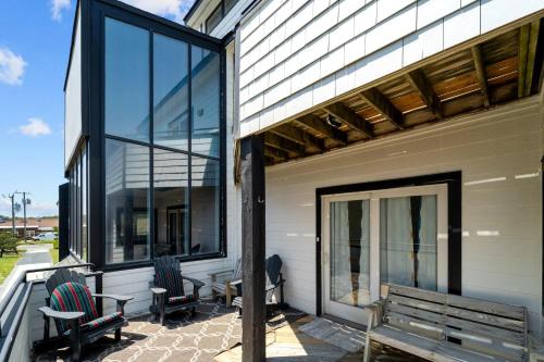 a patio with two chairs and a table and windows at N3709- Game Changer in Nags Head