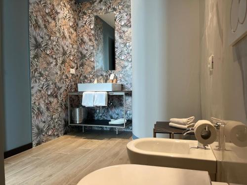 łazienka z umywalką, toaletą i lustrem w obiekcie Hotel Napoleon w Lukce