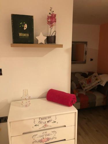 a room with a white dresser with a red towel on it at Peace cottage in Telford
