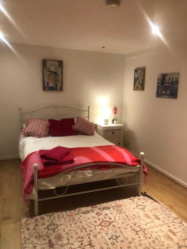 a bedroom with a bed with a red blanket at Peace cottage in Telford