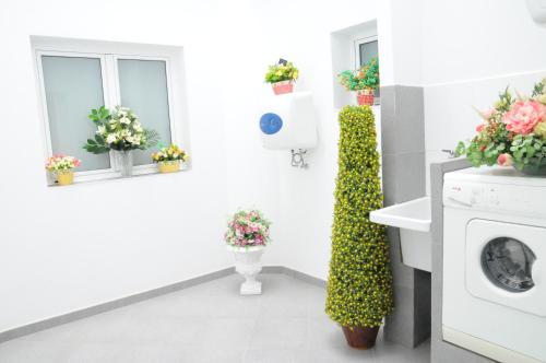 ein Badezimmer mit Blumen an der Wand und eine Waschmaschine in der Unterkunft Helles Appartement im Erdgeschoss in Vecindario