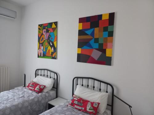 a bedroom with two beds and a painting on the wall at La testuggine in Giussano