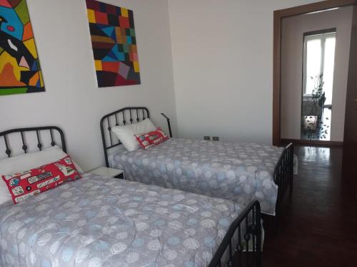a bedroom with two beds and a window at La testuggine in Giussano