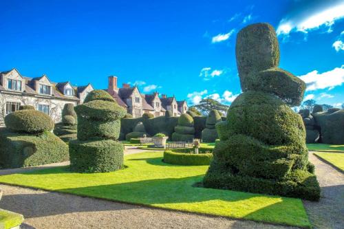 a row of hedges in front of a house at Billesley Manor Hotel & Spa, a Tribute Portfolio Hotel in Stratford-upon-Avon