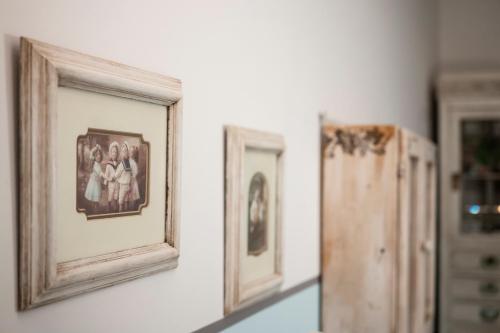 two framed pictures on a wall next to a cabinet at Le Terrazze Del Chianti b&b Residenza d'Epoca e di Charme in Tavarnelle in Val di Pesa