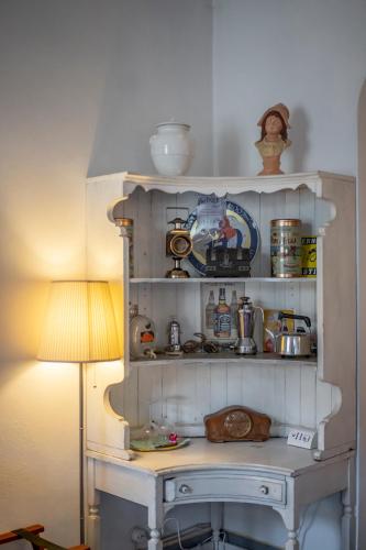 a kitchen with a shelf with various items on it at Le Terrazze Del Chianti b&b Residenza d'Epoca e di Charme in Tavarnelle in Val di Pesa