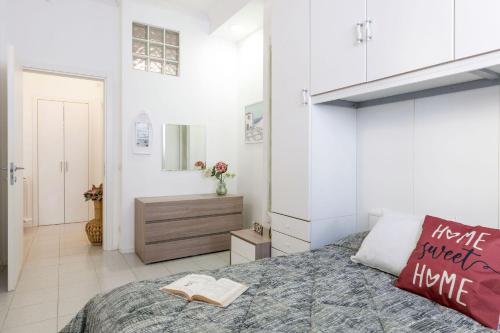 una camera da letto con un letto con un libro sopra di Italian Experience-La Rondine Apartment a Porto Recanati