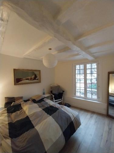 une chambre avec un lit et une grande fenêtre dans l'établissement At Home in Bergerac, à Bergerac