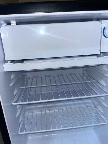 an empty refrigerator with its door open at Suíte Lemos Prêmio in Porto De Galinhas