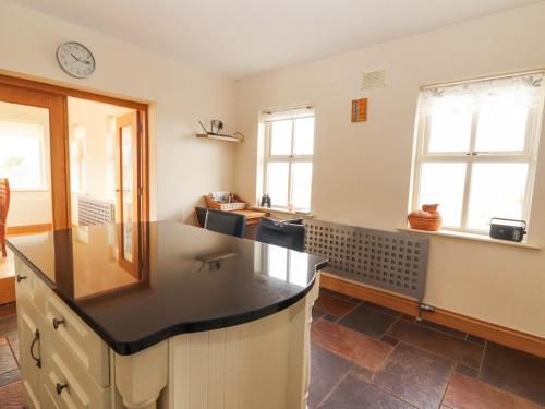 a kitchen with a counter and two windows at Cúnna Bán in Derreen