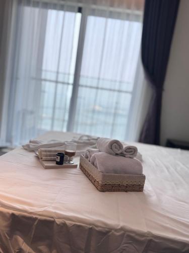 a bed with two towels and a tray with a cup and avisorvisorvisor at Mian Sapphire Home toà S1 S2 in Ha Long