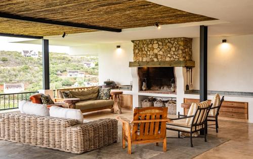 a living room with furniture and a fireplace at Oudewerfskloof Olive Farm in Stilbaai