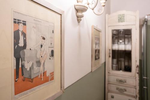 a framed picture of a man in a chair on a wall at Le Terrazze Del Chianti b&b Residenza d'Epoca e di Charme in Tavarnelle in Val di Pesa