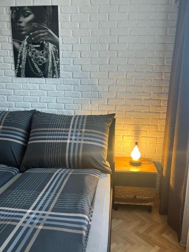 a bedroom with a bed and a side table with a lamp at VITRUVIAN Apartament 13 - Self check in 24h in Reşiţa