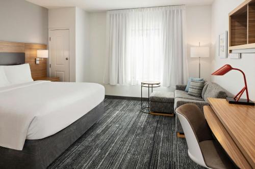 ブルーミントンにあるTownePlace Suites by Marriott Minneapolis near Mall of Americaのベッドとソファのあるホテルの部屋